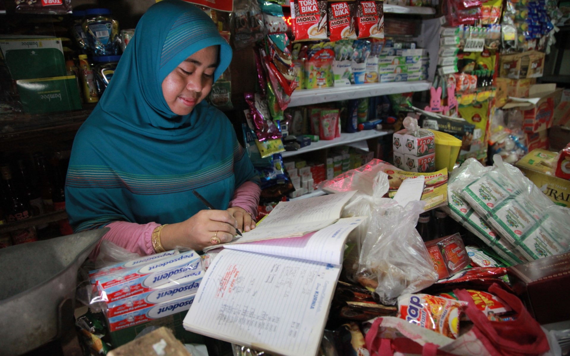 Une femme fait sa comptabilité dans son magasin de détail. 